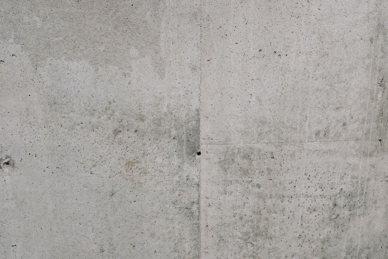 Close-up view of a rough textured concrete wall, ideal for backgrounds.